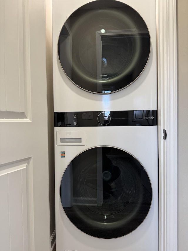 laundry area with stacked washer / drying machine and laundry area