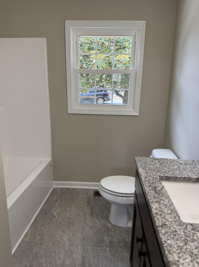 full bathroom featuring visible vents, toilet, a bathing tub, vanity, and baseboards