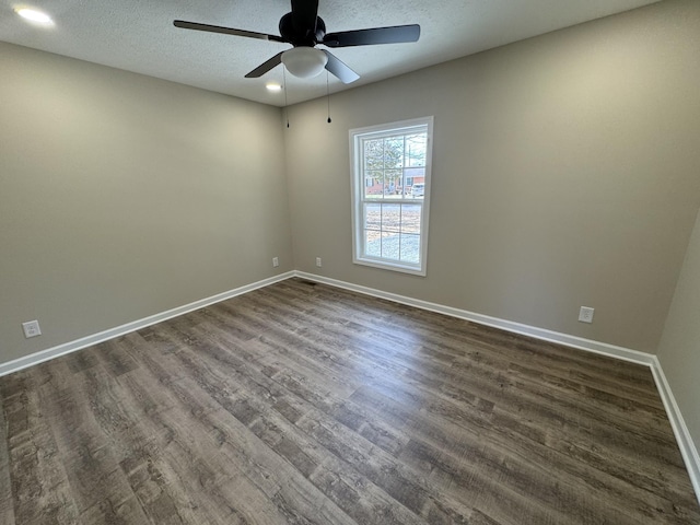 spare room with dark wood-style floors, ceiling fan, a textured ceiling, and baseboards