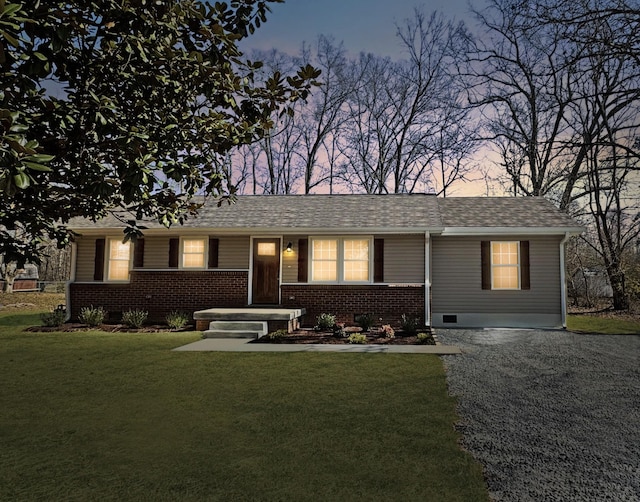 ranch-style home with a shingled roof, crawl space, brick siding, and a front lawn