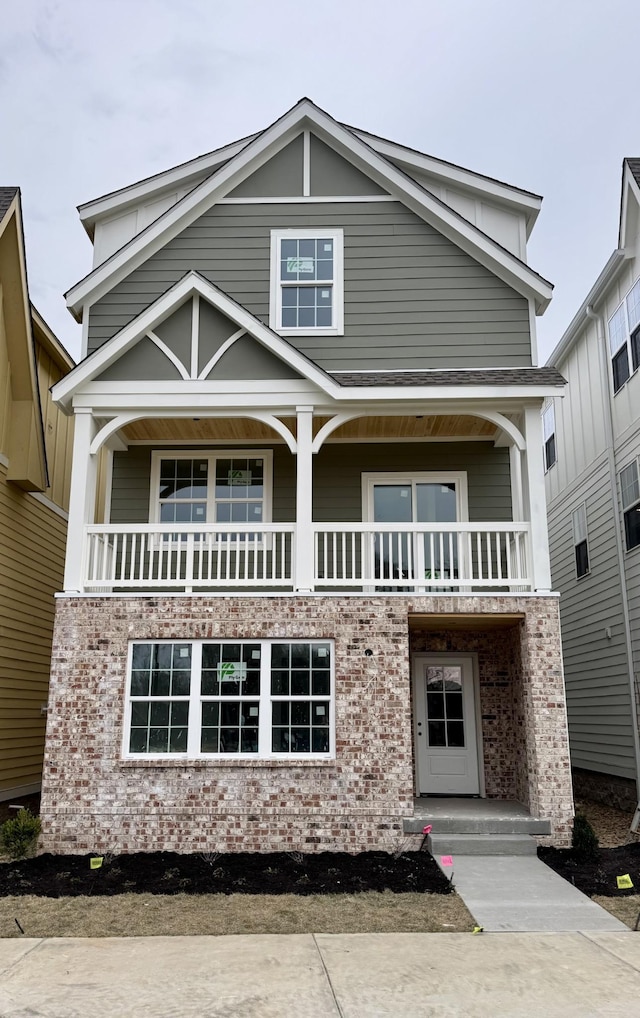 view of front facade with brick siding and a balcony