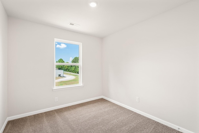 carpeted empty room featuring visible vents and baseboards