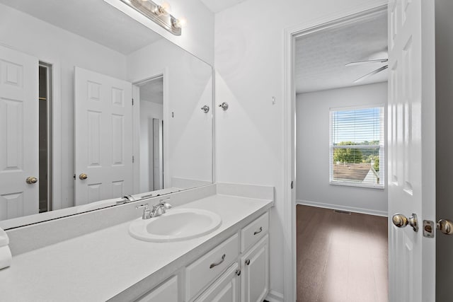 bathroom featuring visible vents, wood finished floors, vanity, and baseboards