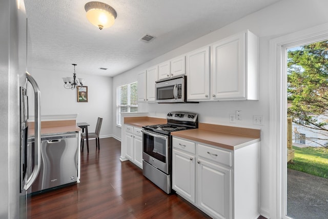 kitchen with stainless steel appliances, dark wood-type flooring, visible vents, and white cabinets