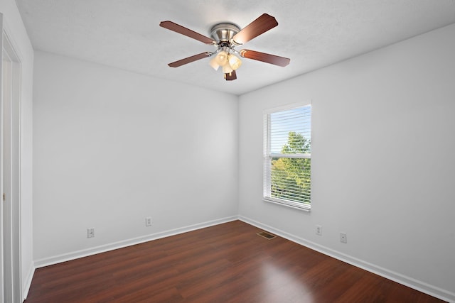 empty room with ceiling fan, wood finished floors, visible vents, and baseboards