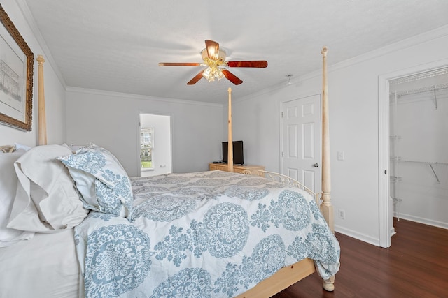 bedroom featuring a ceiling fan, a walk in closet, crown molding, and wood finished floors