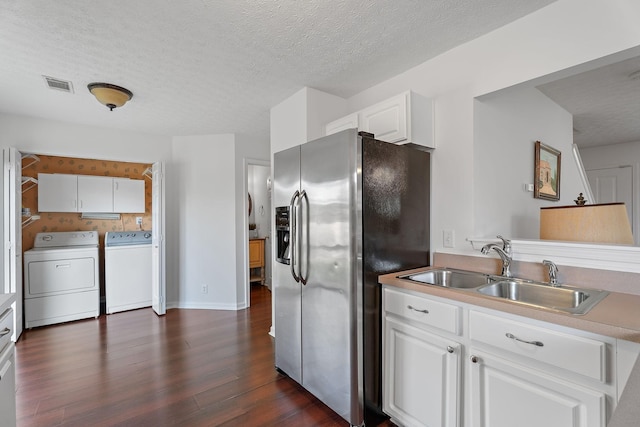 kitchen featuring dark wood-style floors, washer and clothes dryer, visible vents, a sink, and stainless steel fridge with ice dispenser