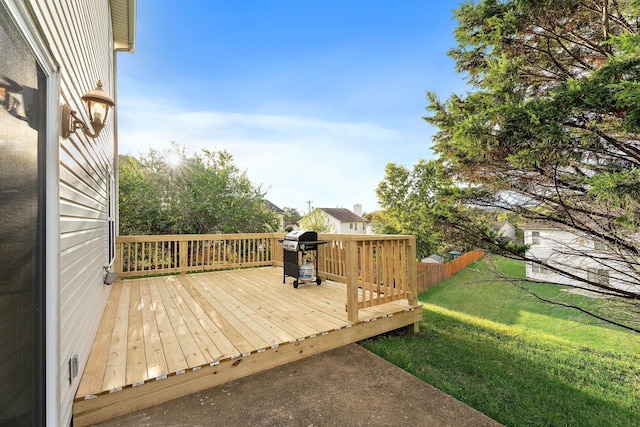 wooden deck featuring grilling area and a lawn