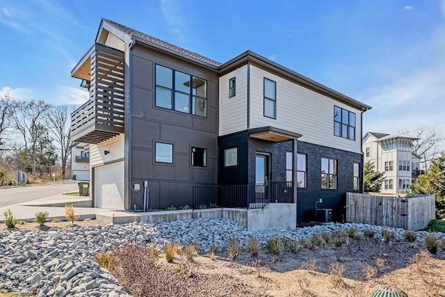 exterior space featuring a garage, fence, and central air condition unit