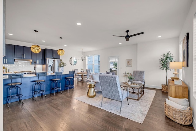 living room featuring ceiling fan, baseboards, dark wood finished floors, and recessed lighting