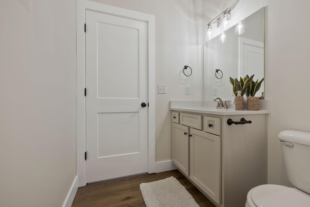 bathroom featuring toilet, wood finished floors, and vanity