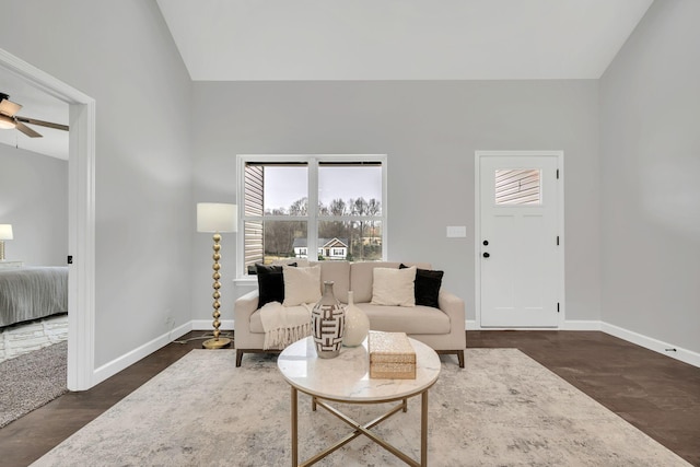 living area with lofted ceiling, a ceiling fan, baseboards, and wood finished floors