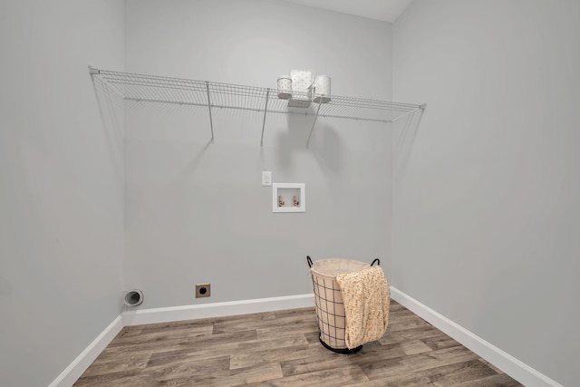 washroom with hookup for a washing machine, hookup for an electric dryer, wood finished floors, laundry area, and baseboards