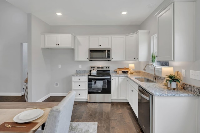 kitchen with stainless steel appliances, a sink, dark wood finished floors, and white cabinetry