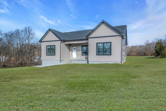 modern farmhouse with a front yard and roof with shingles