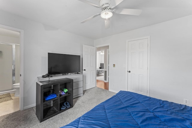 carpeted bedroom featuring ceiling fan, ensuite bath, and baseboards