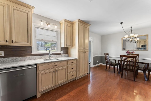 kitchen with dark wood-style flooring, light stone countertops, an inviting chandelier, stainless steel appliances, and a sink