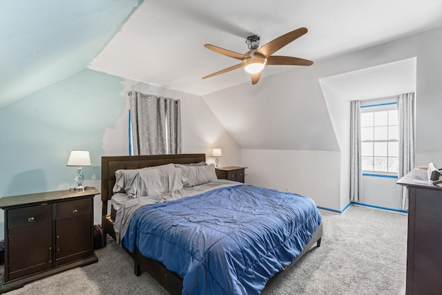 bedroom with light colored carpet, vaulted ceiling, baseboards, and ceiling fan