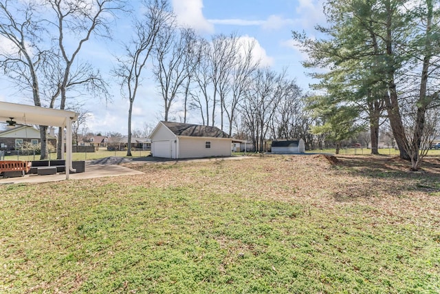 view of yard featuring a patio area, fence, and an outbuilding