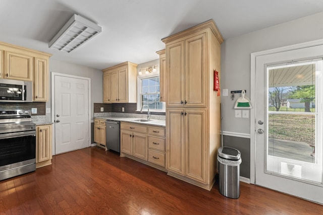 kitchen with appliances with stainless steel finishes, dark wood-style flooring, and decorative backsplash