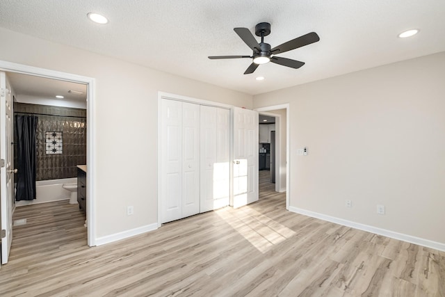 unfurnished bedroom with light wood finished floors, a closet, ensuite bath, and baseboards