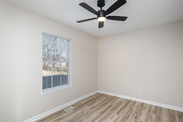 unfurnished room with baseboards, visible vents, a ceiling fan, a textured ceiling, and light wood-type flooring