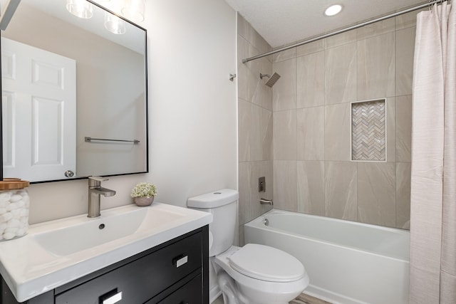 bathroom with a textured ceiling, vanity, toilet, and shower / bath combo with shower curtain