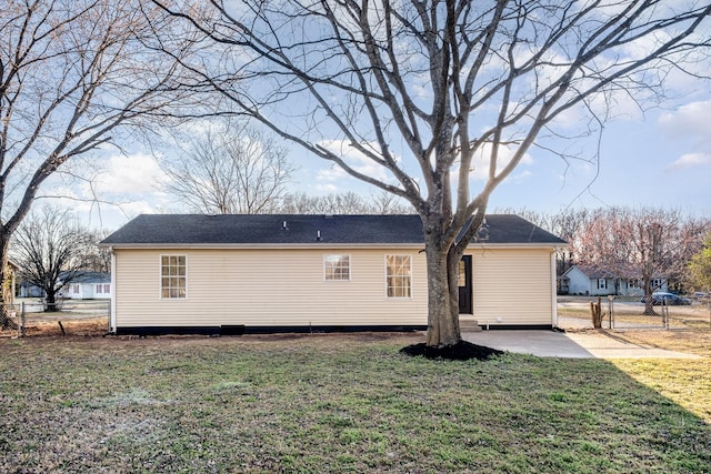 back of property featuring a gate, fence, a patio, and a lawn