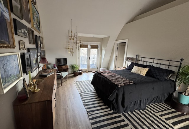 bedroom with access to outside, french doors, wood finished floors, and a high ceiling