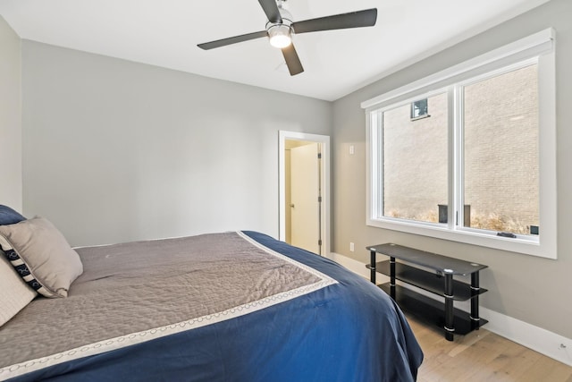 bedroom with a ceiling fan, baseboards, and wood finished floors