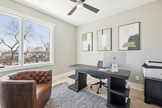 home office with light wood-style flooring, baseboards, and ceiling fan