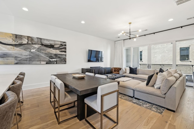 dining space with light wood finished floors, recessed lighting, visible vents, a chandelier, and baseboards