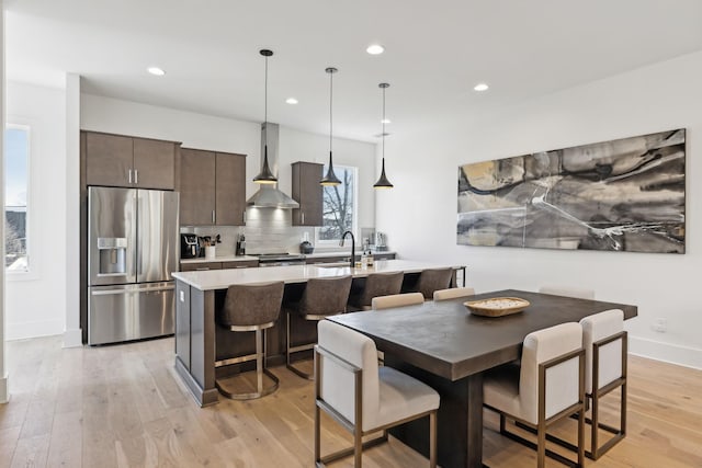 dining area with light wood-style flooring, baseboards, and recessed lighting