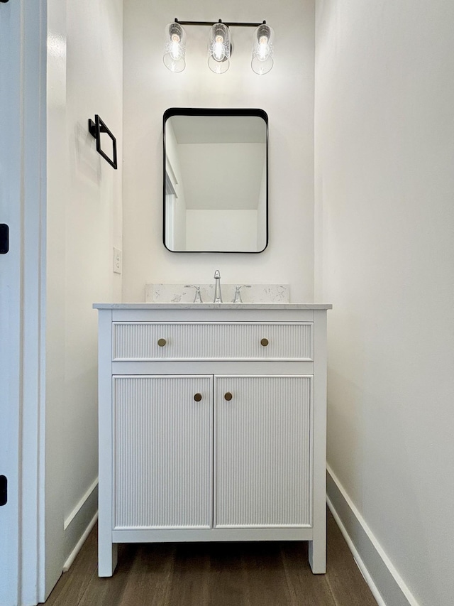 bathroom featuring baseboards, wood finished floors, and vanity