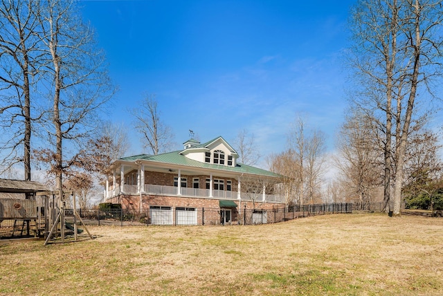 back of property featuring an attached garage, fence private yard, a lawn, and brick siding