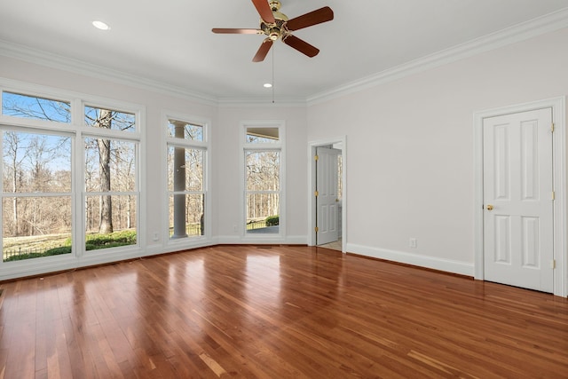 interior space featuring baseboards, wood finished floors, and crown molding