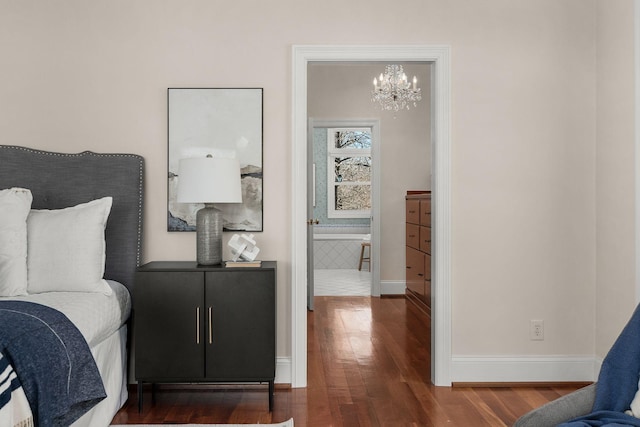 bedroom featuring a notable chandelier, baseboards, and wood finished floors