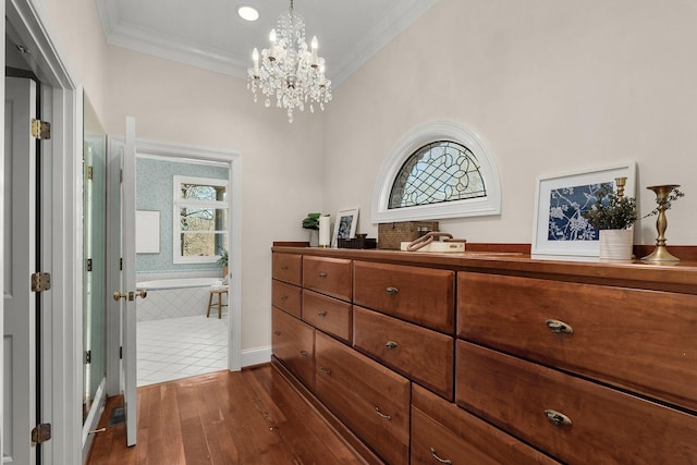 corridor featuring a chandelier, ornamental molding, and dark wood-type flooring