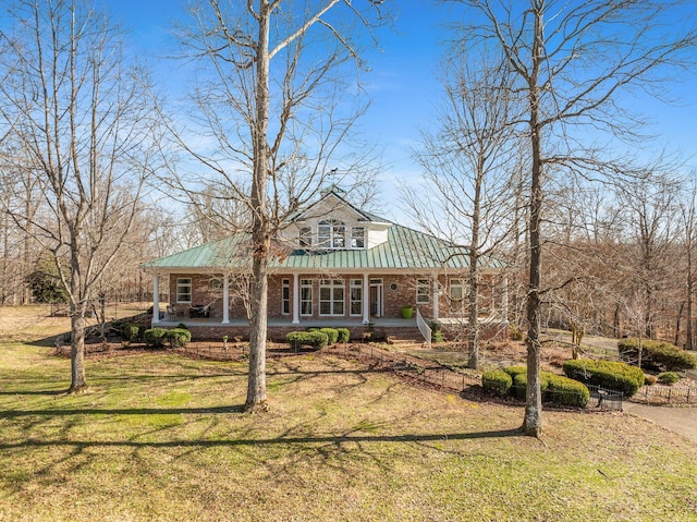 view of front of property with a porch, metal roof, and a front lawn