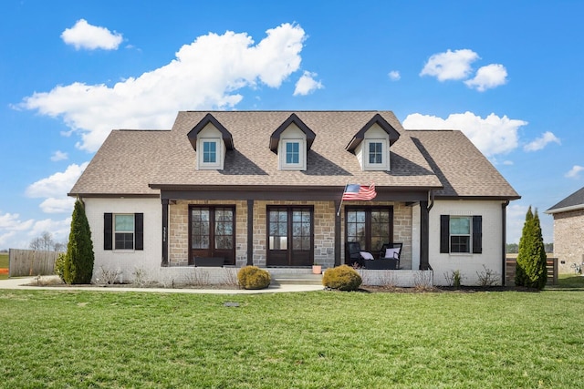 view of front of property with a shingled roof, a porch, and a front yard