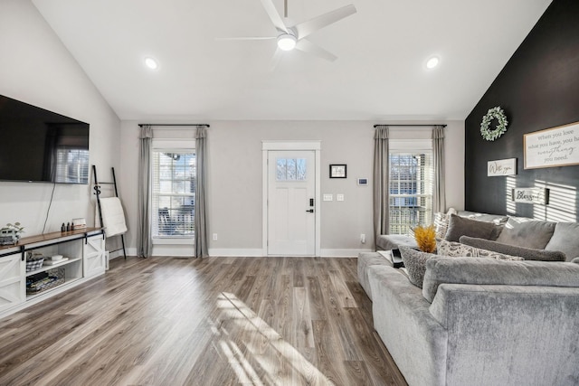 living area with baseboards, ceiling fan, wood finished floors, and a healthy amount of sunlight