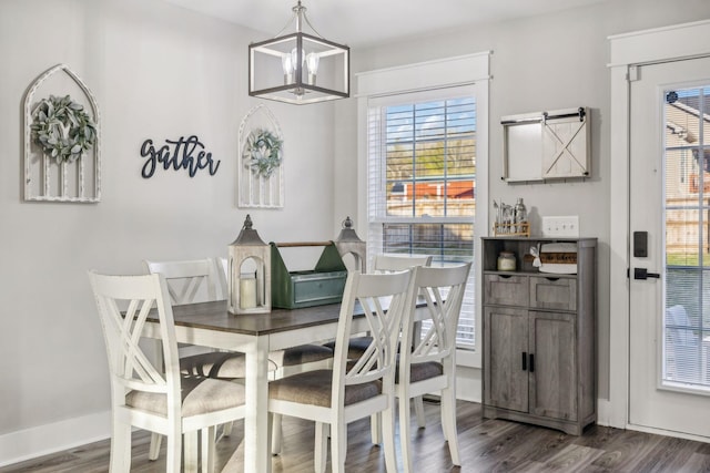 dining room with a healthy amount of sunlight, a notable chandelier, and dark wood-type flooring