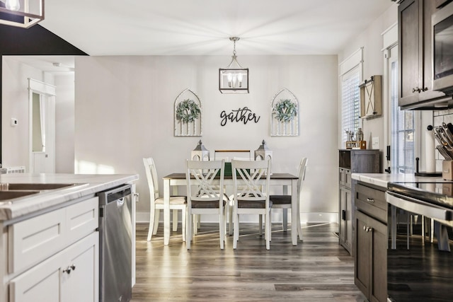 kitchen with white cabinetry, baseboards, hanging light fixtures, appliances with stainless steel finishes, and dark wood-style floors