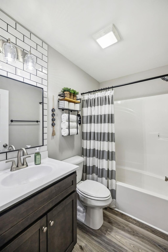 full bath featuring shower / bath combo, vanity, toilet, and wood finished floors