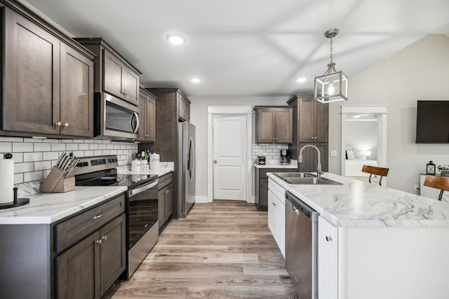 kitchen with dark brown cabinetry, stainless steel appliances, and a sink