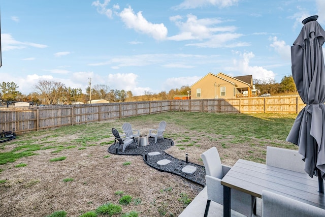 view of yard with a fenced backyard and a fire pit