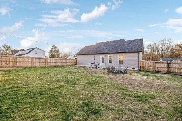 back of property featuring crawl space, a fenced backyard, a lawn, and roof with shingles