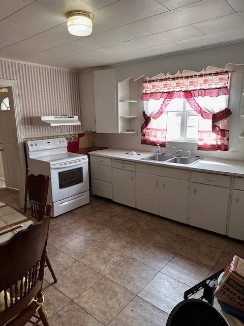 kitchen with white range with electric cooktop, light countertops, white cabinetry, a sink, and wallpapered walls