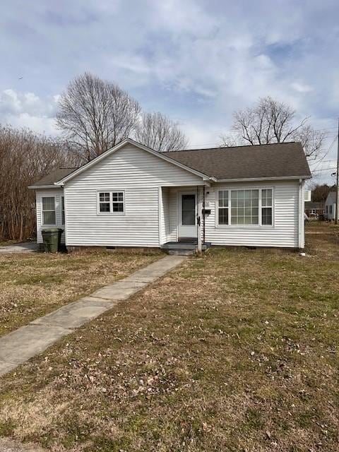 view of front of property with crawl space, roof with shingles, and a front yard