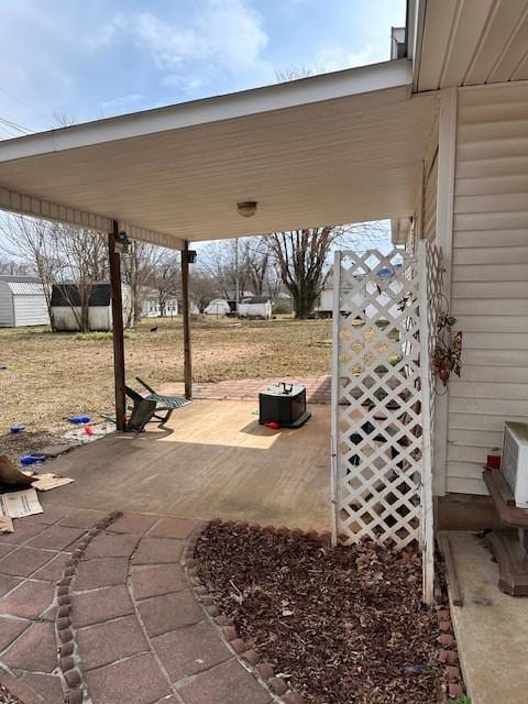 view of patio / terrace featuring an attached carport and an outdoor structure